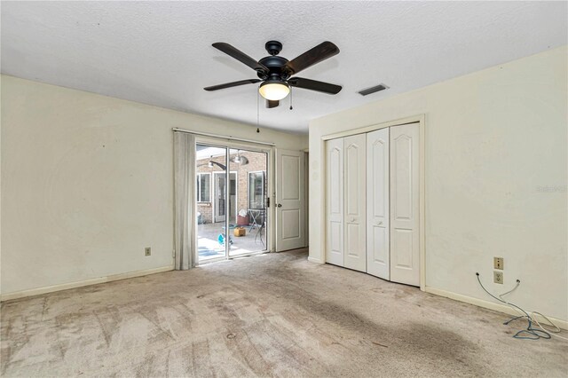 unfurnished bedroom featuring a textured ceiling, access to outside, and carpet