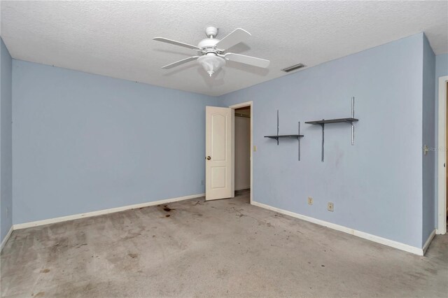 empty room with baseboards, a textured ceiling, ceiling fan, and visible vents