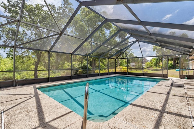 pool featuring glass enclosure and a patio