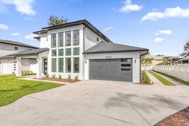 4405 Rockledge Rd, Orlando, FL 32807 - modern home featuring stucco siding, a garage, concrete driveway, and fence