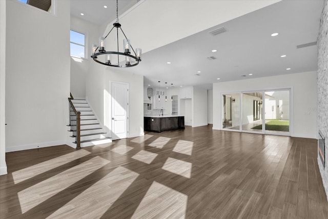 4405 Rockledge Rd, Orlando, FL 32807 - unfurnished living room with stairs, recessed lighting, a chandelier, visible vents, and wood finished floors