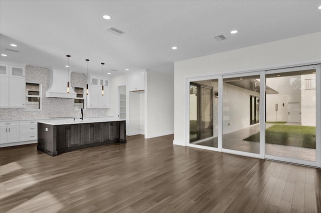 4405 Rockledge Rd, Orlando, FL 32807 - kitchen with light countertops, custom exhaust hood, visible vents, white cabinets, and dark wood-type flooring