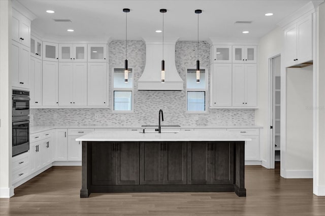 4405 Rockledge Rd, Orlando, FL 32807 - kitchen featuring light countertops, a sink, double oven, dark wood-style floors, and a kitchen island with sink