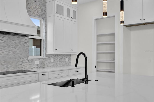 4405 Rockledge Rd, Orlando, FL 32807 - kitchen featuring black electric cooktop, custom exhaust hood, a sink, and white cabinets