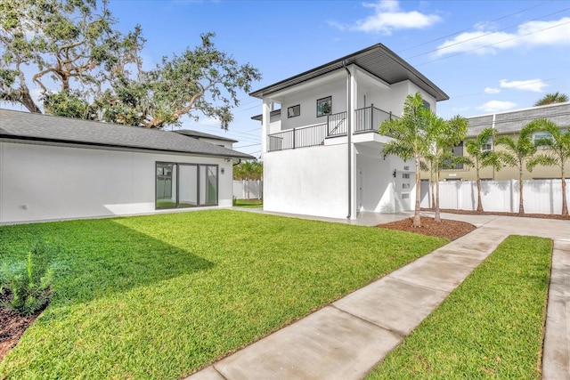 4405 Rockledge Rd, Orlando, FL 32807 - rear view of property with stucco siding, fence, a balcony, a lawn, and a garage