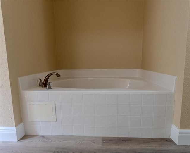 full bath with a bath and a textured wall