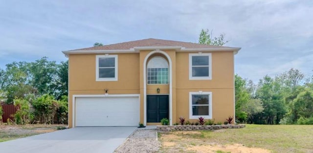 traditional-style house with stucco siding, an attached garage, and concrete driveway