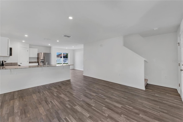 1032 Cannock Dr, Kissimmee, FL 34758 - unfurnished living room featuring stairway, recessed lighting, dark wood-style flooring, baseboards, and visible vents