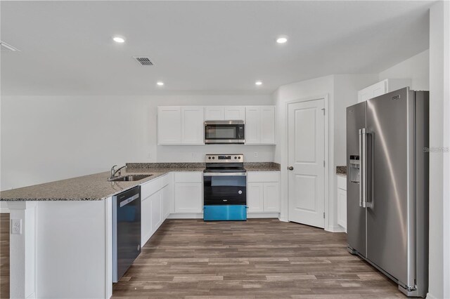 1032 Cannock Dr, Kissimmee, FL 34758 - kitchen featuring stainless steel appliances, a sink, visible vents, white cabinets, and a peninsula