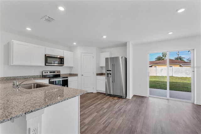 1032 Cannock Dr, Kissimmee, FL 34758 - kitchen featuring a sink, light stone counters, visible vents, white cabinets, and appliances with stainless steel finishes
