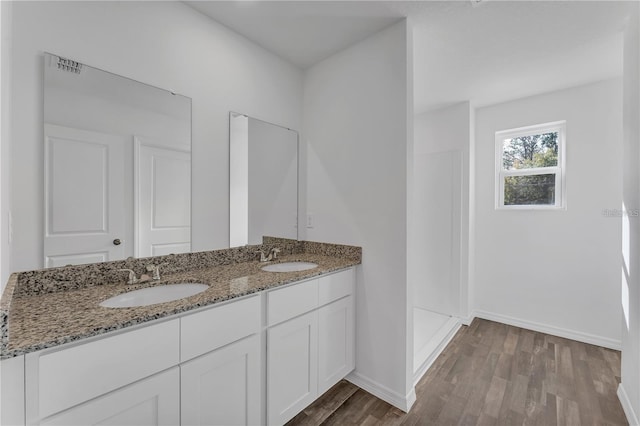 1032 Cannock Dr, Kissimmee, FL 34758 - bathroom featuring double vanity, a sink, baseboards, and wood finished floors