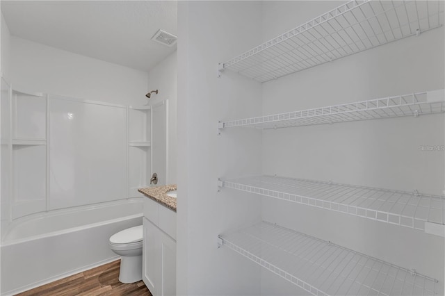 1032 Cannock Dr, Kissimmee, FL 34758 - bathroom with toilet, vanity, wood finished floors, visible vents, and shower / bath combination