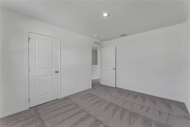 1032 Cannock Dr, Kissimmee, FL 34758 - unfurnished bedroom with carpet floors, a textured ceiling, baseboards, and visible vents
