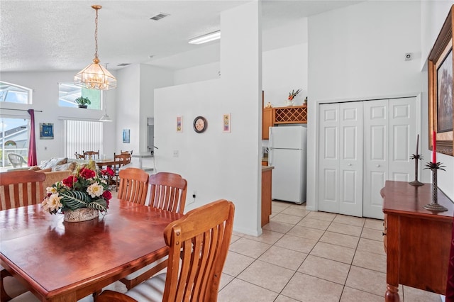 202 Aylesbury Ln, Davenport, FL 33837 - dining area featuring an inviting chandelier, a high ceiling, light tile patterned flooring, and visible vents