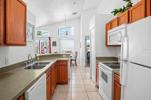 202 Aylesbury Ln, Davenport, FL 33837 - kitchen featuring a textured ceiling, visible vents, brown cabinets, a sink, and white appliances