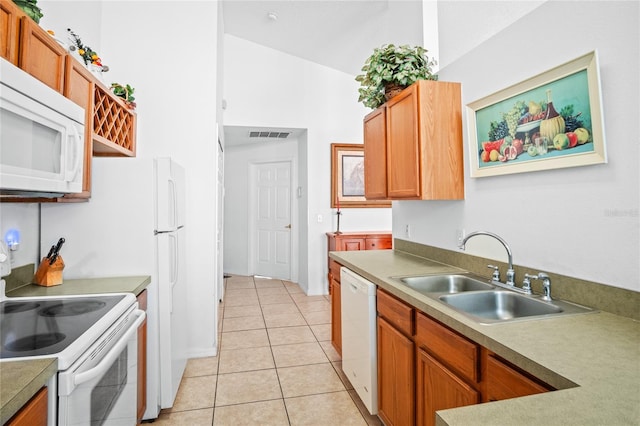 202 Aylesbury Ln, Davenport, FL 33837 - kitchen with brown cabinetry, light tile patterned flooring, white appliances, light countertops, and a sink