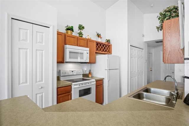 202 Aylesbury Ln, Davenport, FL 33837 - kitchen featuring visible vents, brown cabinets, a sink, light countertops, and white appliances