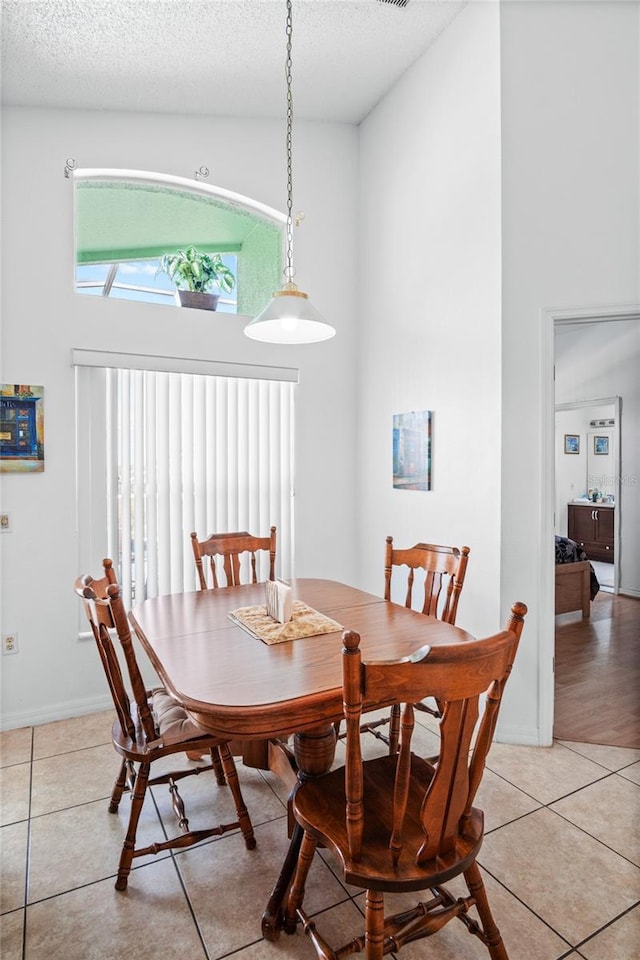 202 Aylesbury Ln, Davenport, FL 33837 - dining room featuring a textured ceiling, a towering ceiling, and light tile patterned floors