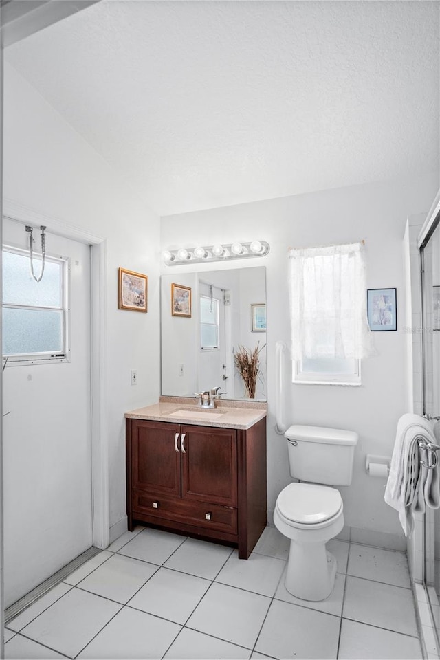 202 Aylesbury Ln, Davenport, FL 33837 - bathroom featuring vanity, a shower with door, tile patterned floors, and toilet
