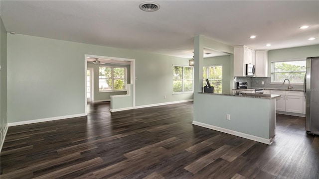 kitchen featuring stainless steel appliances, dark wood-style floors, tasteful backsplash, and visible vents