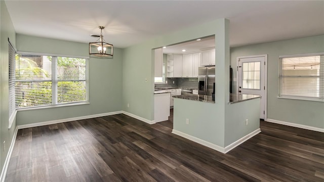 kitchen with white cabinetry, stainless steel appliances, dark wood-type flooring, and baseboards