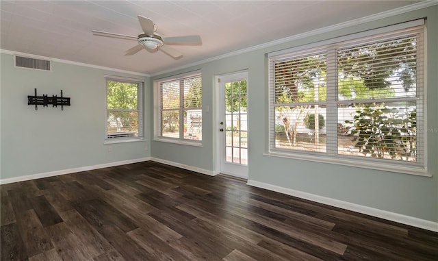 empty room featuring dark wood-type flooring, baseboards, ornamental molding, and visible vents