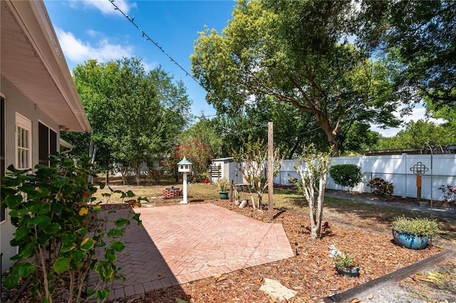 view of yard with a patio, an outbuilding, and a fenced backyard