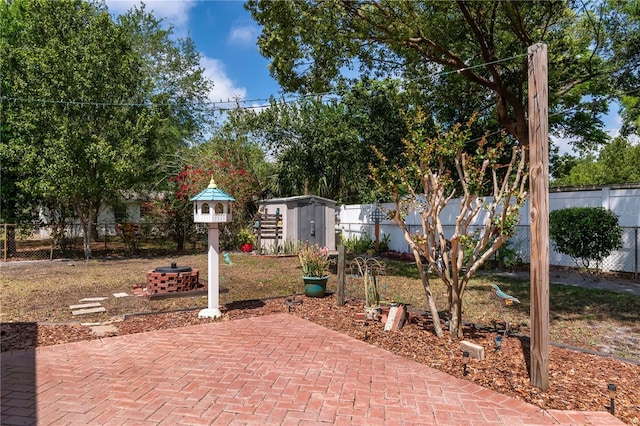 view of patio with an outdoor structure, a fenced backyard, an outdoor fire pit, and a storage shed