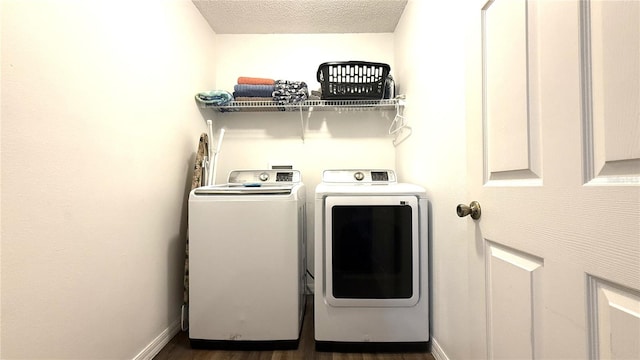 laundry room featuring laundry area, a textured ceiling, baseboards, wood finished floors, and washer and clothes dryer