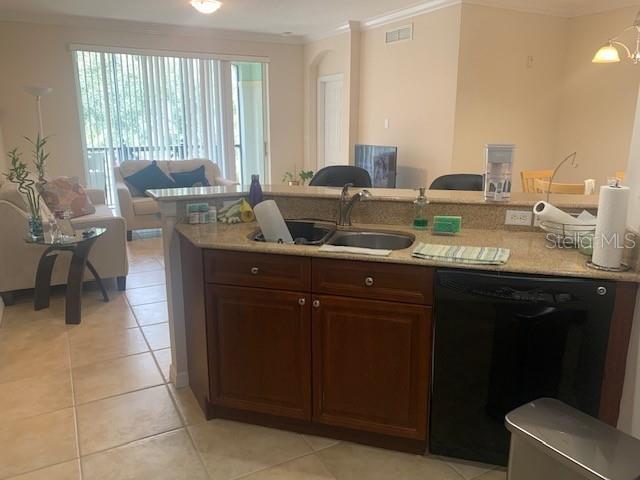 11446 Jasper Kay Ter Unit 202, Windermere, FL 34786 - kitchen with dishwasher, crown molding, light countertops, light tile patterned floors, and a sink