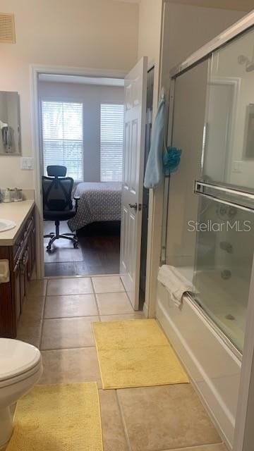 11446 Jasper Kay Ter Unit 202, Windermere, FL 34786 - ensuite bathroom featuring bath / shower combo with glass door, tile patterned floors, vanity, and toilet