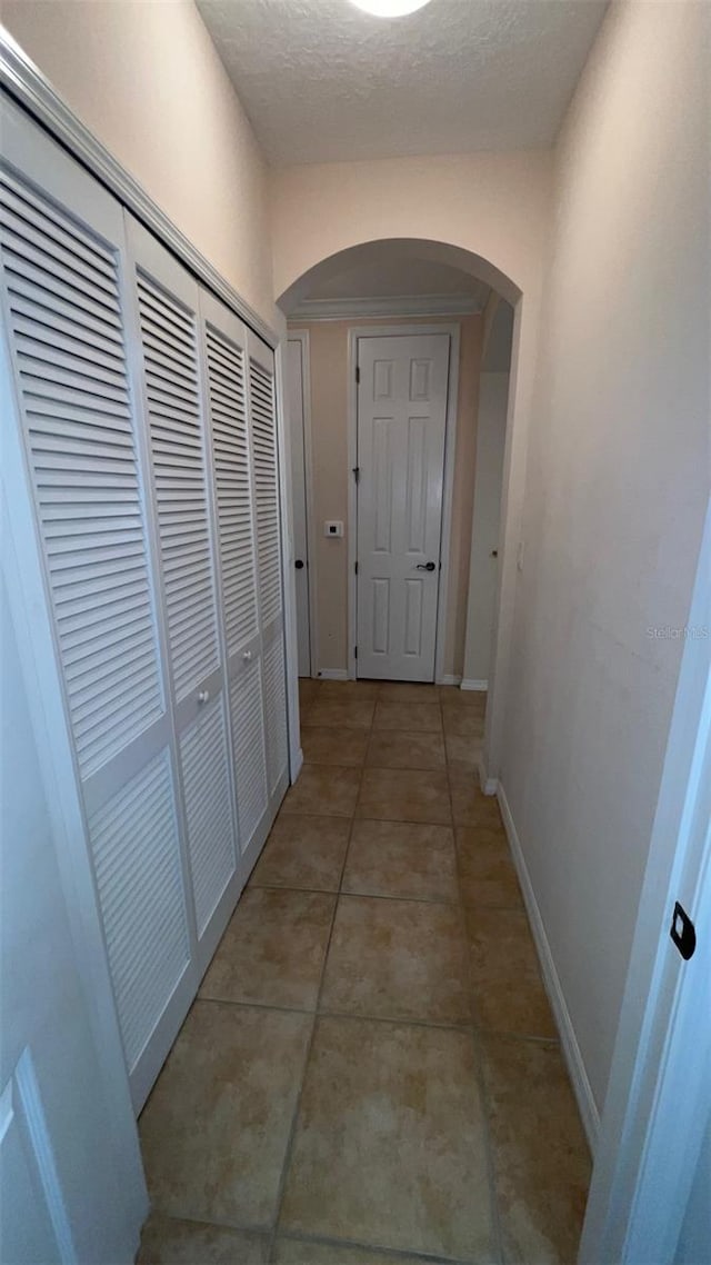 11446 Jasper Kay Ter Unit 202, Windermere, FL 34786 - corridor with arched walkways, baseboards, light tile patterned floors, and a textured ceiling