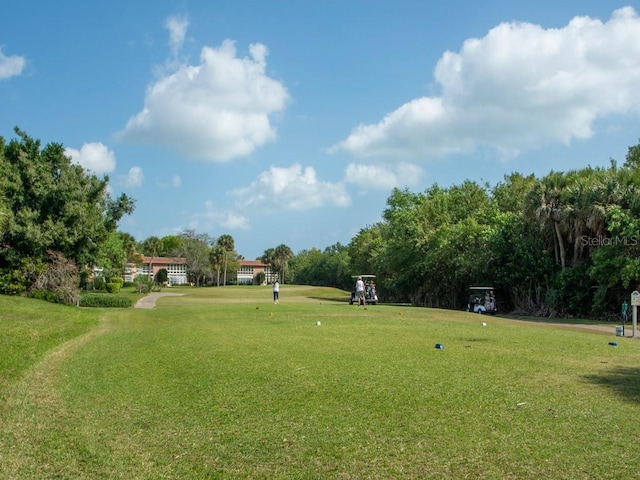 view of home's community featuring a yard and view of scattered trees
