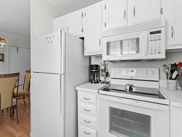 kitchen featuring white appliances, a textured ceiling, white cabinets, ornamental molding, and wood finished floors
