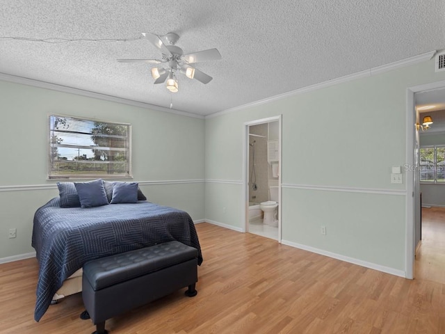 bedroom with wood finished floors, a textured ceiling, crown molding, connected bathroom, and baseboards