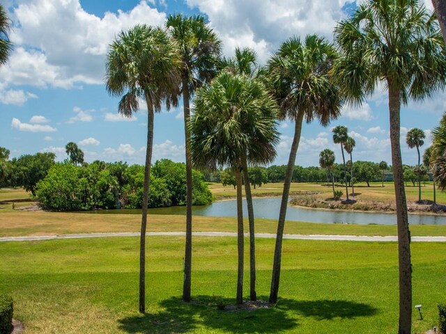 surrounding community featuring a water view and a lawn