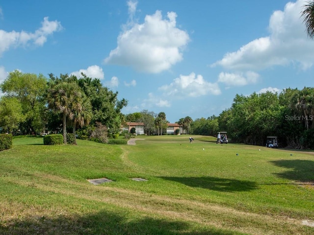 view of property's community with a lawn and view of golf course