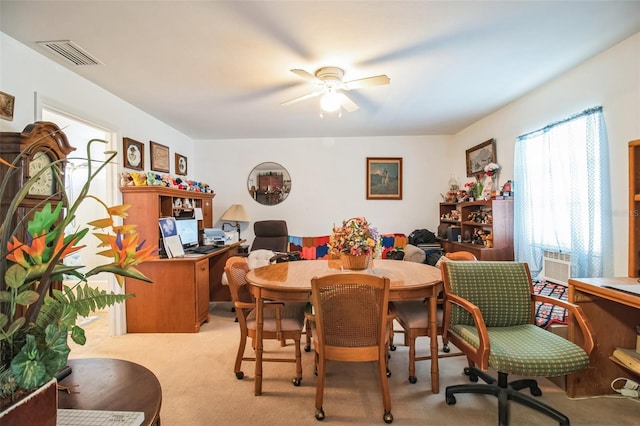 dining room with cooling unit, ceiling fan, visible vents, and light colored carpet