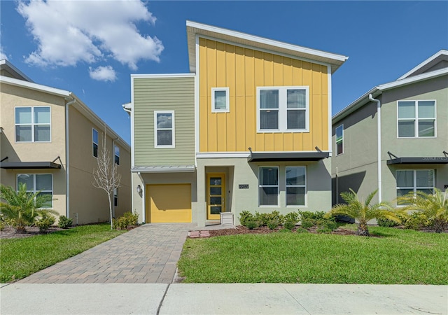 2760 Bookmark Dr, Kissimmee, FL 34746 - view of front facade with an attached garage, a front lawn, board and batten siding, and decorative driveway