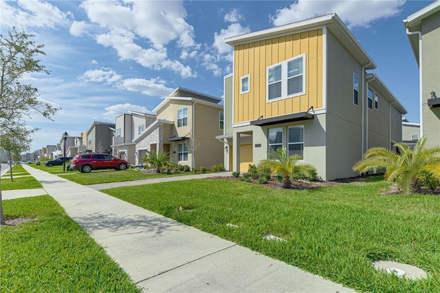 2760 Bookmark Dr, Kissimmee, FL 34746 - view of front of property featuring an attached garage, board and batten siding, a residential view, driveway, and a front yard