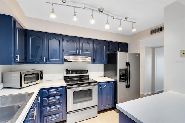 kitchen featuring blue cabinetry, appliances with stainless steel finishes, under cabinet range hood, and visible vents