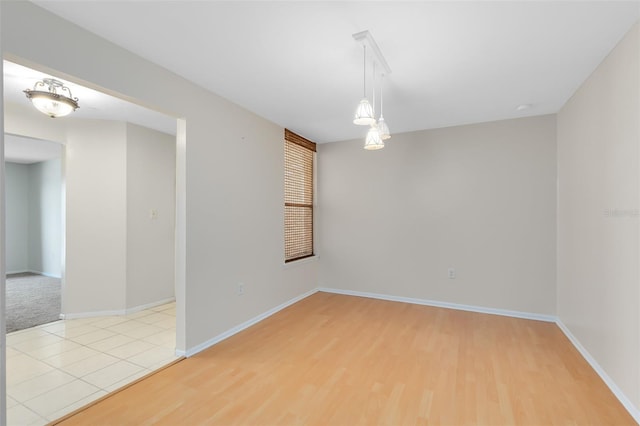 unfurnished room featuring baseboards and light wood-type flooring