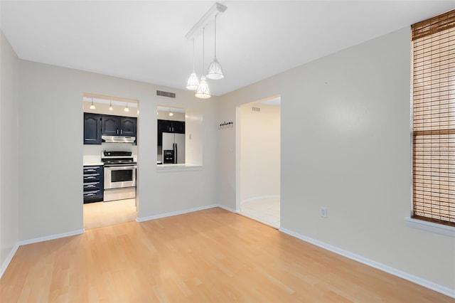 interior space with light wood-type flooring, baseboards, and visible vents