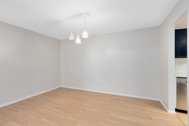 unfurnished room featuring baseboards and light wood-style flooring