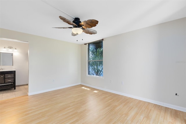 unfurnished room with baseboards, ceiling fan, and light wood-style flooring