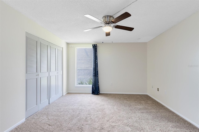 unfurnished bedroom featuring baseboards, a closet, carpet floors, and a textured ceiling