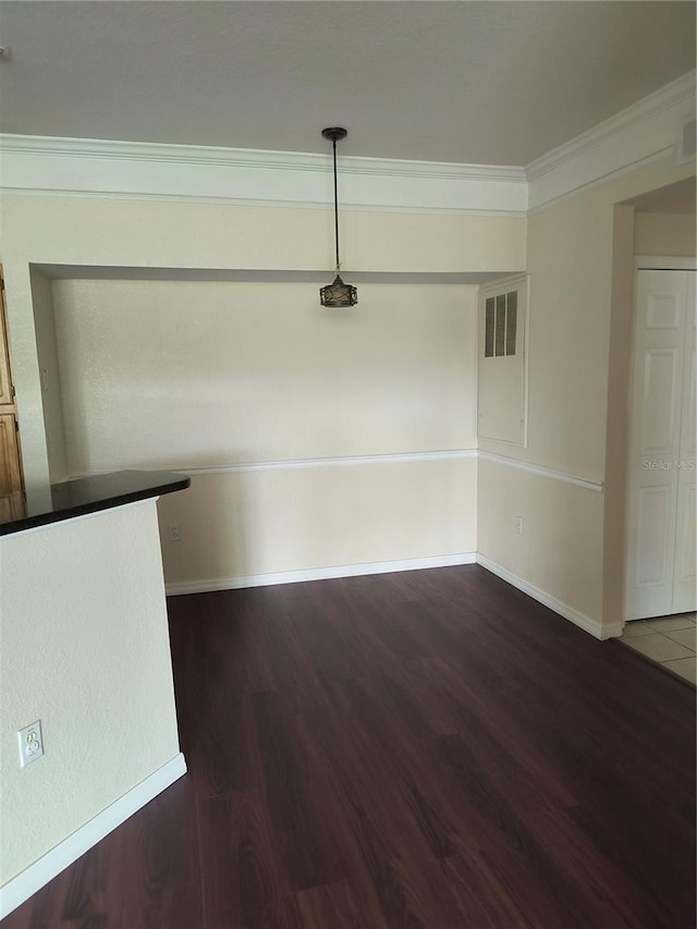 unfurnished room with baseboards, visible vents, crown molding, and dark wood-style flooring