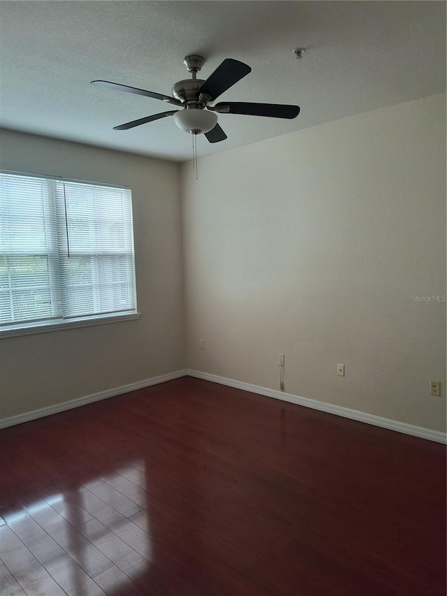 unfurnished room featuring a ceiling fan, baseboards, and wood finished floors