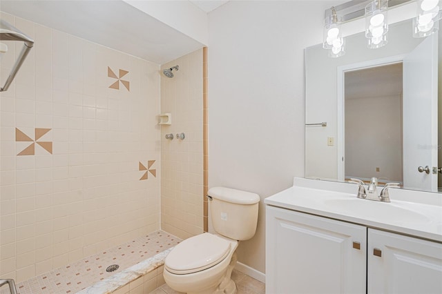 bathroom with a tile shower, toilet, and vanity