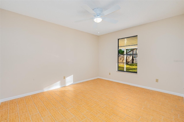 empty room featuring ceiling fan and baseboards